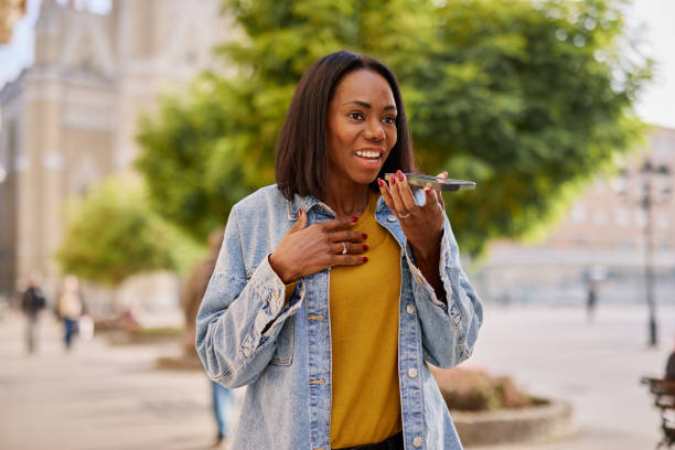 istock Smiling Woman Using Smartphone Outdoors in Urban Setting 2182825345