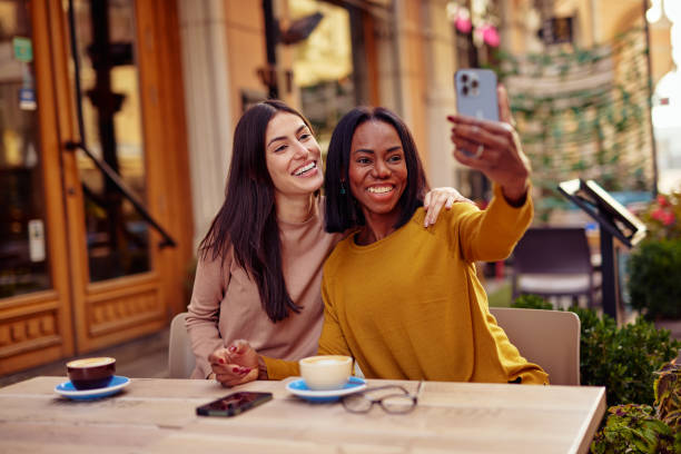 istock Two Friends Laughing Together Over Coffee at a Cozy Cafe 2182825718
