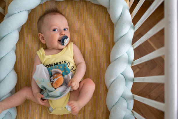 istock Baby boy with pacifier lying in the crib 2182826347