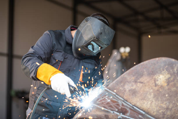 istock Professional welder welding metal with sparks flying in workshop 2182826423