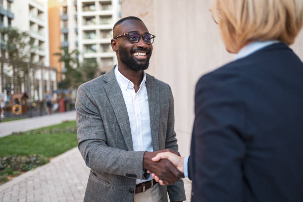 istock Two professionals shaking hands outdoors in an urban setting 2182827826