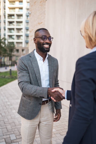 istock Business professionals exchanging a warm handshake outdoors 2182827830