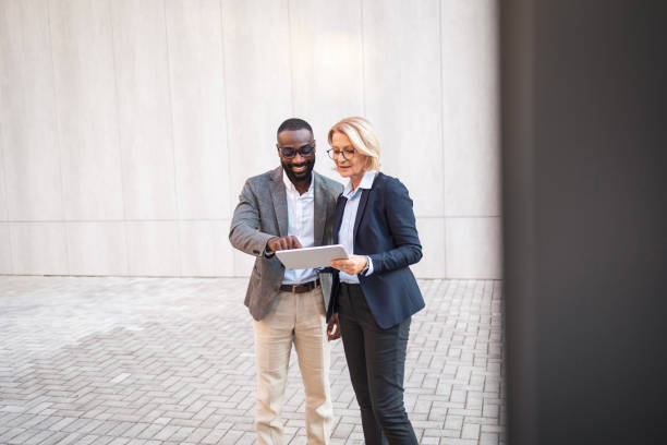 istock Professional business colleagues discussing work on digital tablet outside office 2182827866