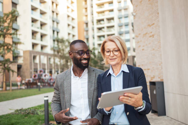 istock Business professionals collaborating and reviewing documents outdoors 2182827877