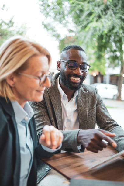 istock Two professionals discussing work on a laptop outdoors 2182827937