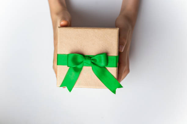 istock Gift box with green ribbon and bow in hands on white background isolated 2182828709