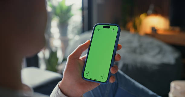 istock Green screen, hand and reading with smartphone, home and subscription to app, browsing and article. Scrolling, display and person with mobile, tracking markers and online for news, digital and lounge 2182828739