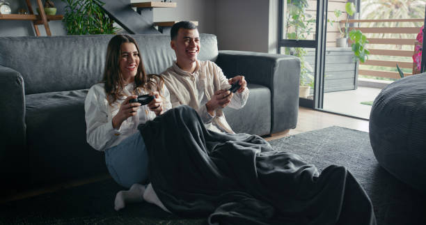 istock Happy, gaming and couple with controller, love and bonding with fun, next level and romance in living room. Playing, man and woman in lounge, competition and subscription for website in house 2182828971