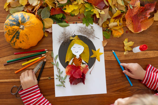 istock Sweet child, boy, applying leaves using glue while doing arts and crafts at home 2182829015