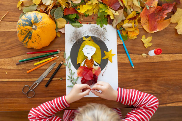 istock Sweet child, boy, applying leaves using glue while doing arts and crafts at home 2182829041