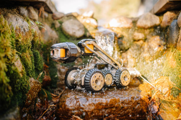 istock A rugged inspection robot navigating over wet rocks and moss, with water splashing around it, illustrating durability and outdoor capability. 2182833638