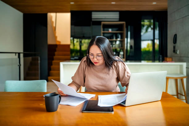 istock Focused Businesswoman Analyzing Documents at Home Office Desk 2182833933
