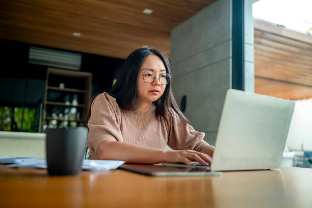 istock Focused Woman Working Remotely on Laptop in Modern Home Office 2182833940