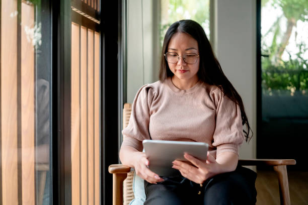 istock Young Woman Relaxing Indoors Using a Digital Tablet 2182833988
