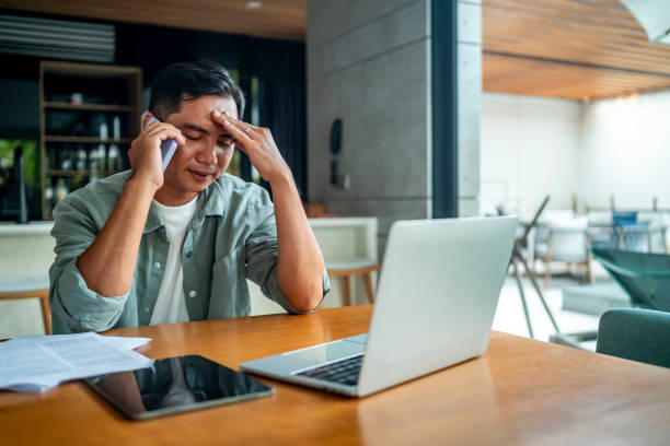 istock Stressed Businessman Talking on Phone in Modern Office Setting 2182834002