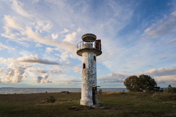 Traditional sea navigation, old abandoned lighthouse on Neeme Peninsula on a summer day, sky with clouds.