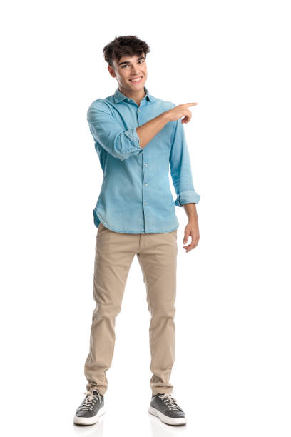 istock happy young student with big smile pointing finger to side 2182838286