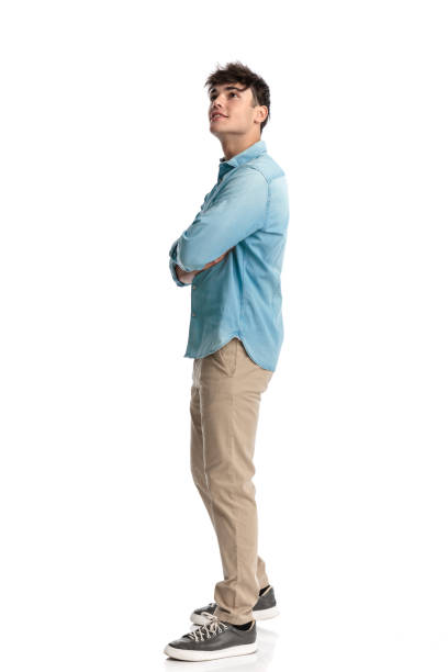 istock side view of happy man looking up and crossing arms while waiting 2182839070