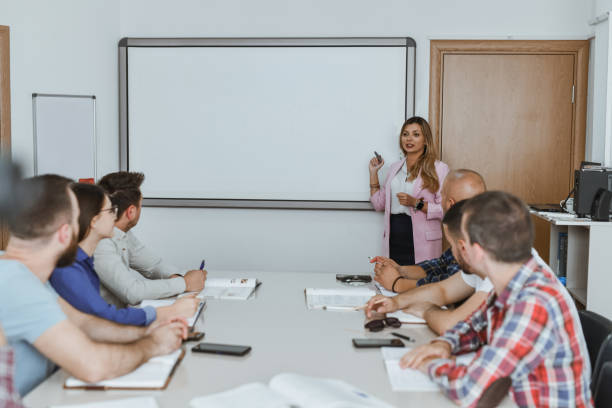 istock Female Professor Explaining in Front of White Board Students Listening With Interest 2182840884