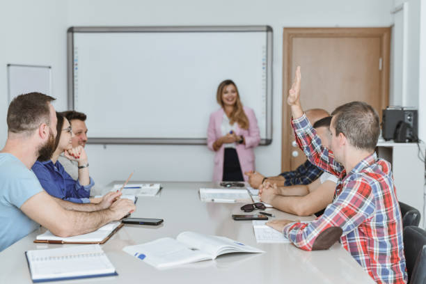 istock Curious Male Student Raising Hand to Ask Female Professor Question in Class 2182841331
