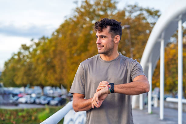 Young athlete monitors his smartwatch for timing during outdoor training