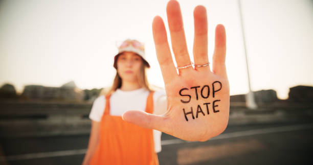 istock Hands, stop hate and equality for person with writing, sign and protest for racism, peace and inclusion. Woman, palm and outdoor for activism, accountability and human rights on bridge 2182844526