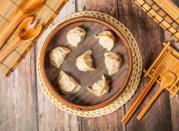 istock Steamed Shrimp Dumplings with chopsticks and spoon served in bamboo steamer isolated on wooden table top view of taiwan food 2182844706