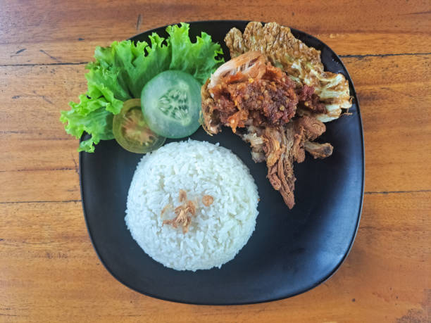 istock Nasi Ayam Penyet Or Crispy Boneless Rice Chicken Smashed With Chili Condiment. Serving With Lettuce, Cucumber, Tomato And Fried Onion. Indonesia Food Menu. Top View. 2182850874