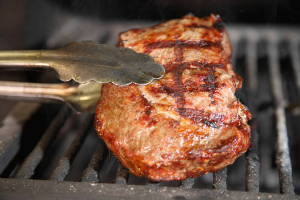Cooking steak on the grill and coals. Roasting steak in a restaurant.