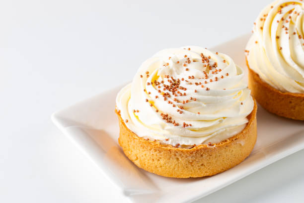 istock Lemon tartlets with whipped cream, sprinkles and chocolate chips on white background 2182853355