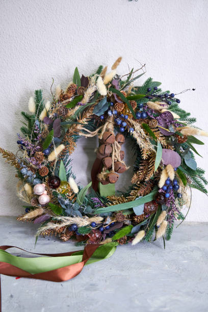istock modern Christmas wreath with needles and dried flowers on a light background 2182856159