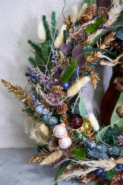 istock modern Christmas wreath with needles and dried flowers on a light background 2182856272