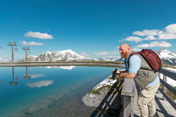 Handsome redhead senior man enjoying a moment of downtime during a forest bathing meditation trip in the Austrian Alps
