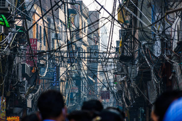 DELHI INDIA-November 27, 2021: View of bazar street full of overhead electric wires, crowded market and  rustic buildings and  of Chawri Bazaar and chandni chawk in Old Delhi, India