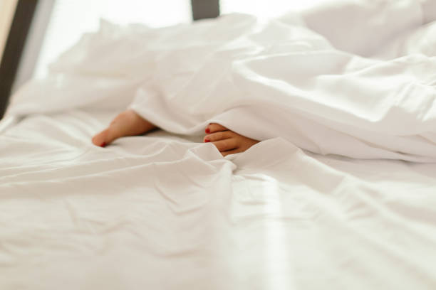 istock Woman's feet peeking under the duvet 2182864562