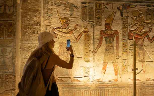 istock Woman using smartphone and taking picture while visiting the inner rooms inside the temple of Abu Simbel, in southern Egypt in Nubia next to Lake Nasser. Temple of Pharaoh Ramss II 2182867140