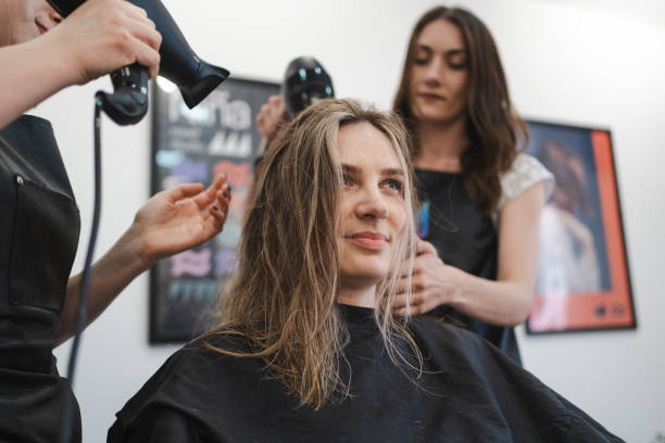 istock Two Stylists Drying Client’s Hair 2182867442