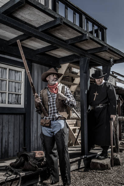 istock Handsome Black Cowboy with a priest in an authentic wild west setting 2182875009