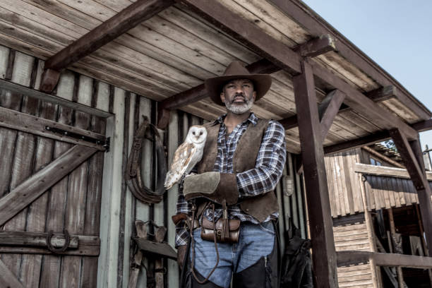 istock Handsome Black Cowboy with an owl in an authentic wild west setting 2182875320