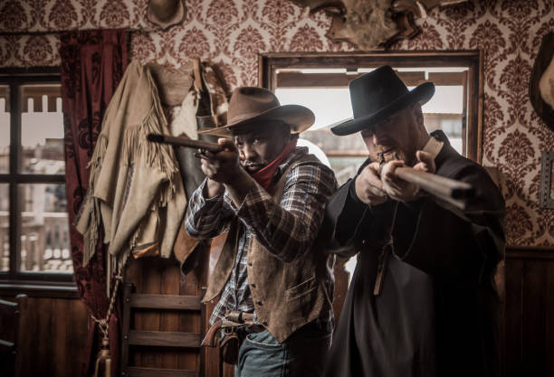 istock Handsome Black Cowboy with a priest in an authentic wild west setting 2182876727