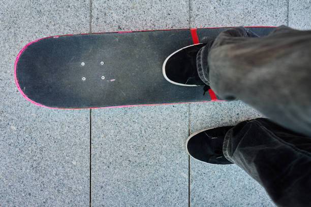 Two Teenage Skateboarders Sit In The City Square With Their Skateboard