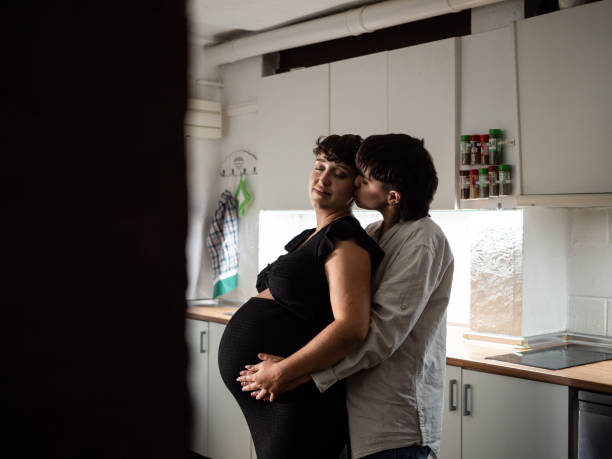 istock Expecting lesbian couple embraces and share a tender moment in a cozy kitchen 2182880403