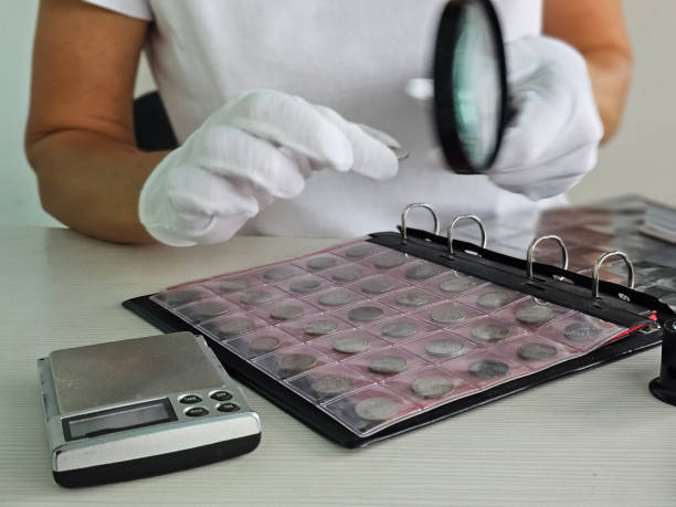 istock A numismatist examines rare coins using a magnifying glass in a collector workspace 2182881822