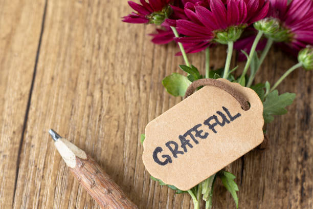 istock Grateful, handwritten text on rustic note with flower bouquet and wooden pencil, closeup 2182887558