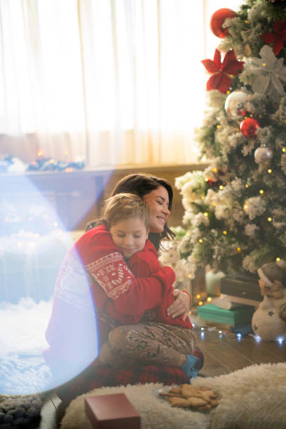 istock Mother and son hug by the Christmas tree 2182890382