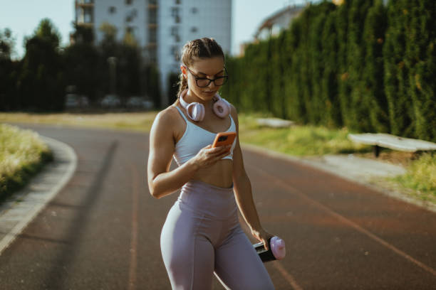 istock Young Woman Using a Smartphone at the Running Track 2182892210