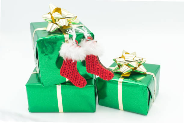 Green gift boxes with golden ribbons. Isolated on a white background. Decorated with red socks.