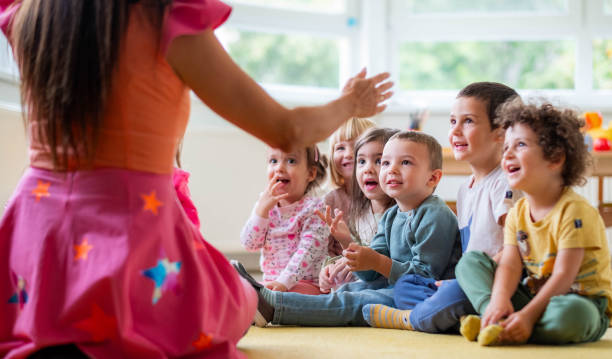 istock cute children sit next to the teacher 2182893103
