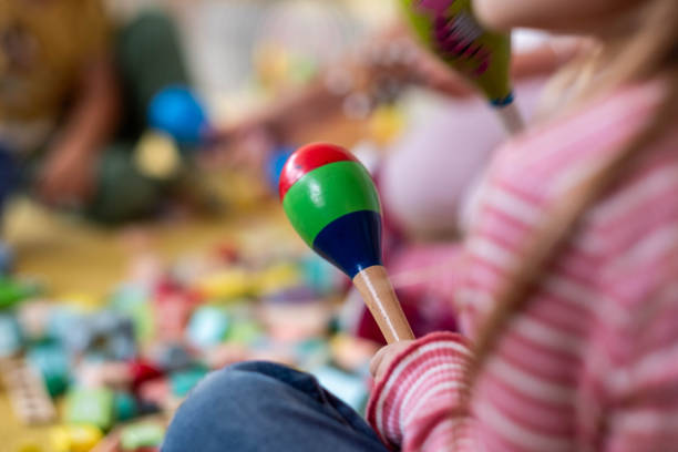 children in kindergarten play with rattles and blocks