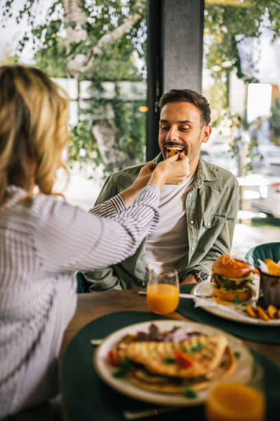 istock Cute couple feeding each other in a restaurant. 2182896204